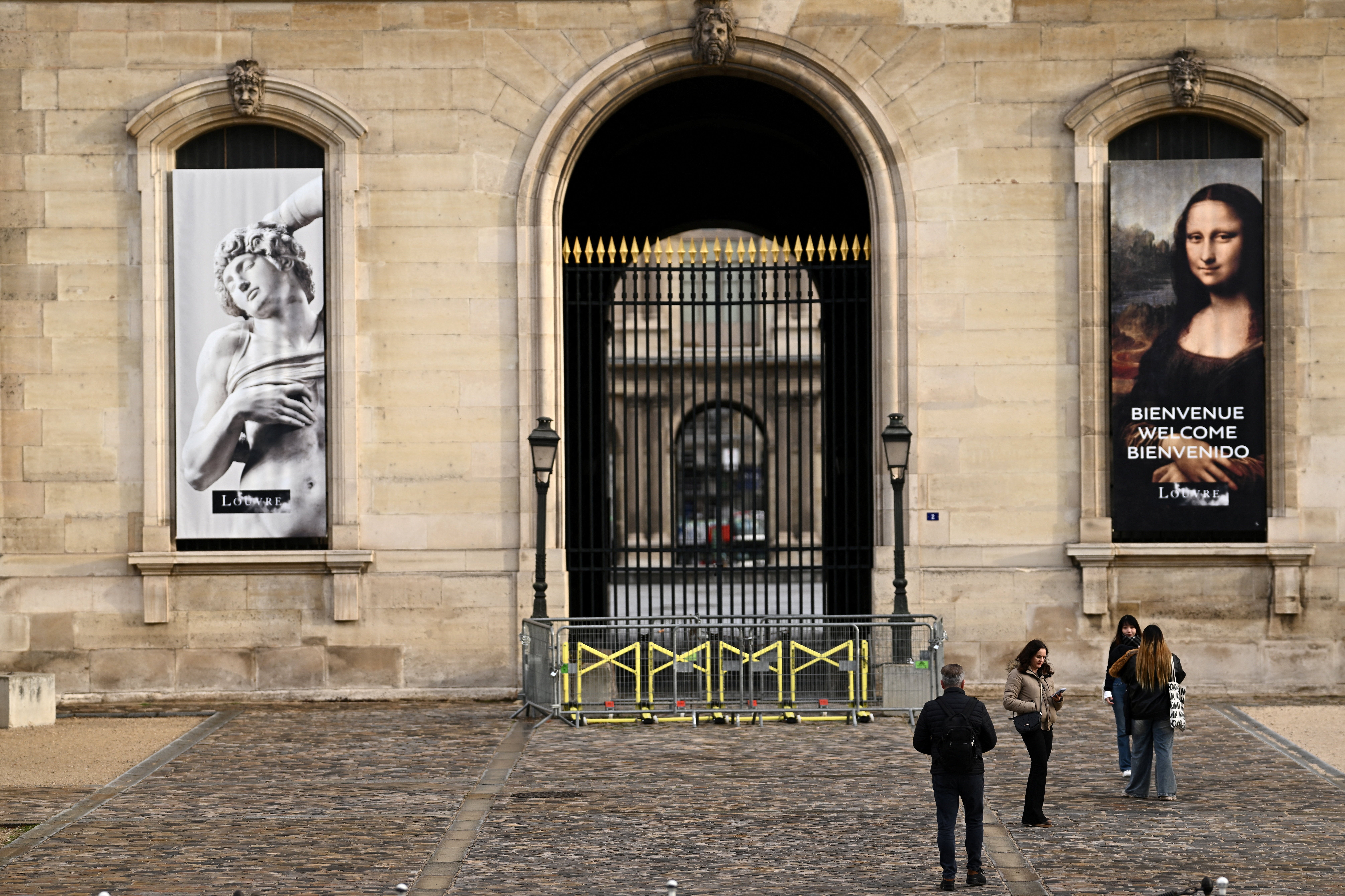 People stand in front of the Louvre Museum on Saturday