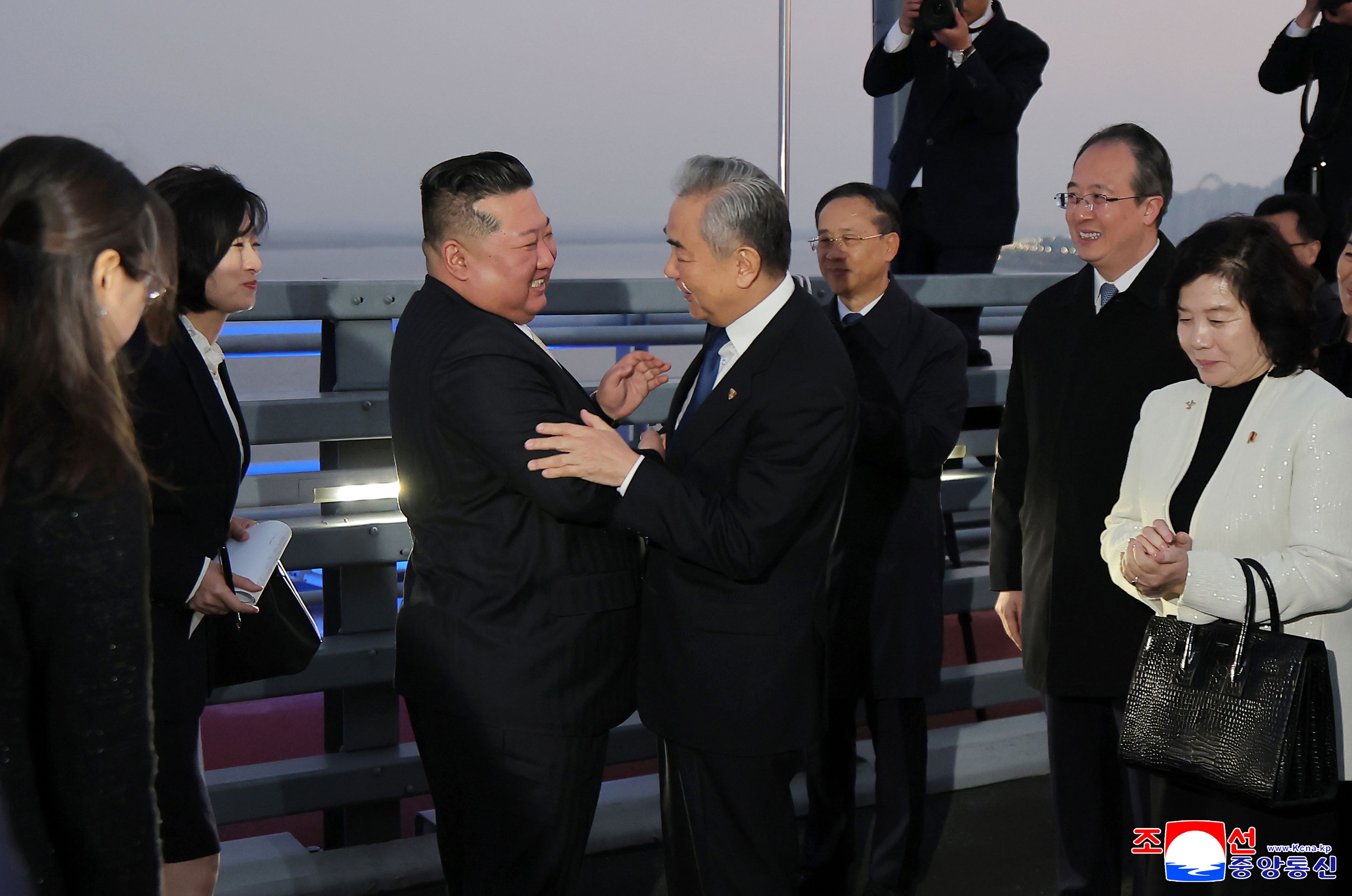 Kim Jong Un, center left, bids farewell to Chinese Foreign Minister Wang Yi on the New Yalu River Bridge, that connects the two countries, after his visit to Dandong, China