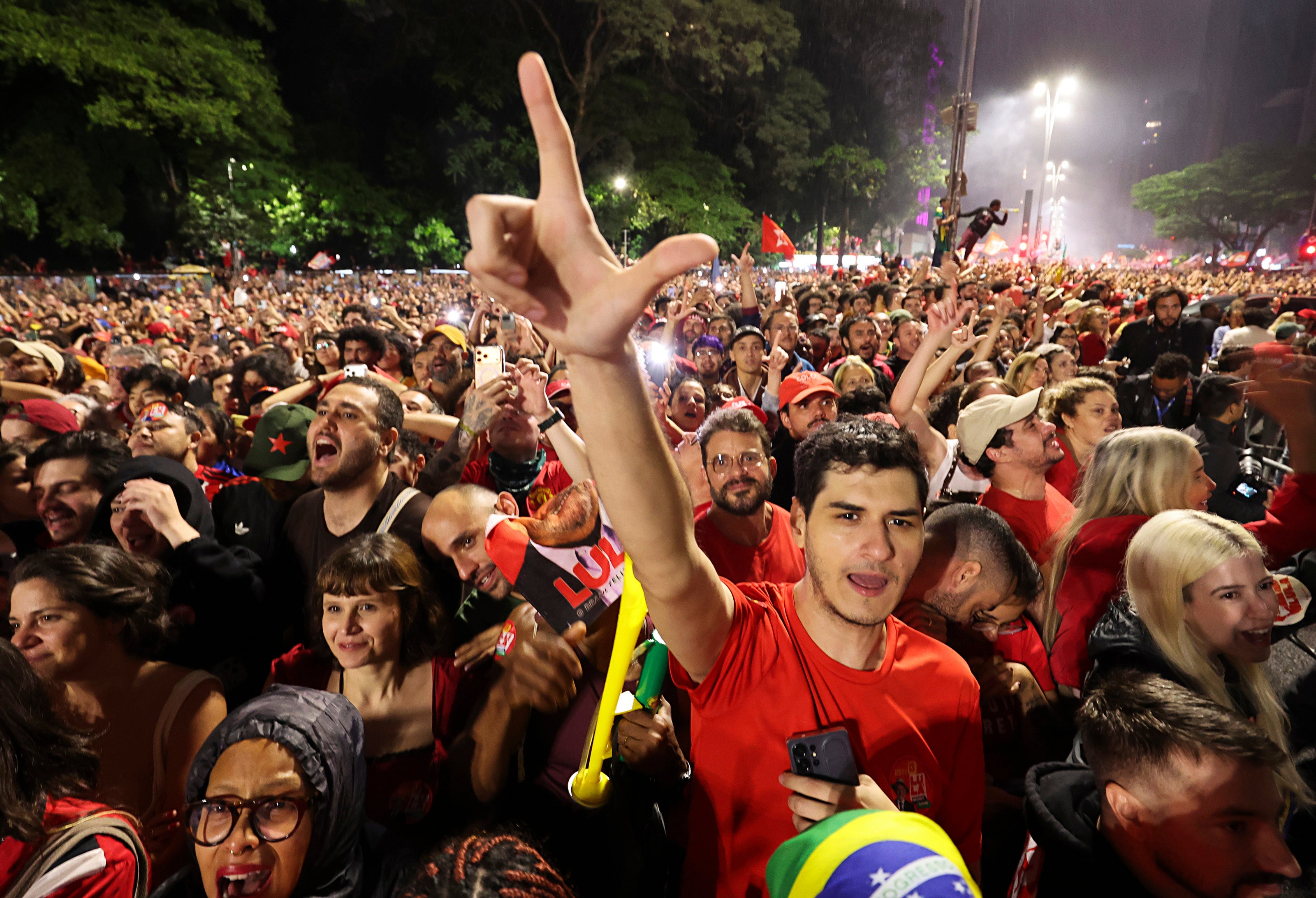 Lula's supporters celebrate with hand gestures of an 'L' in honour of him, on Sunday