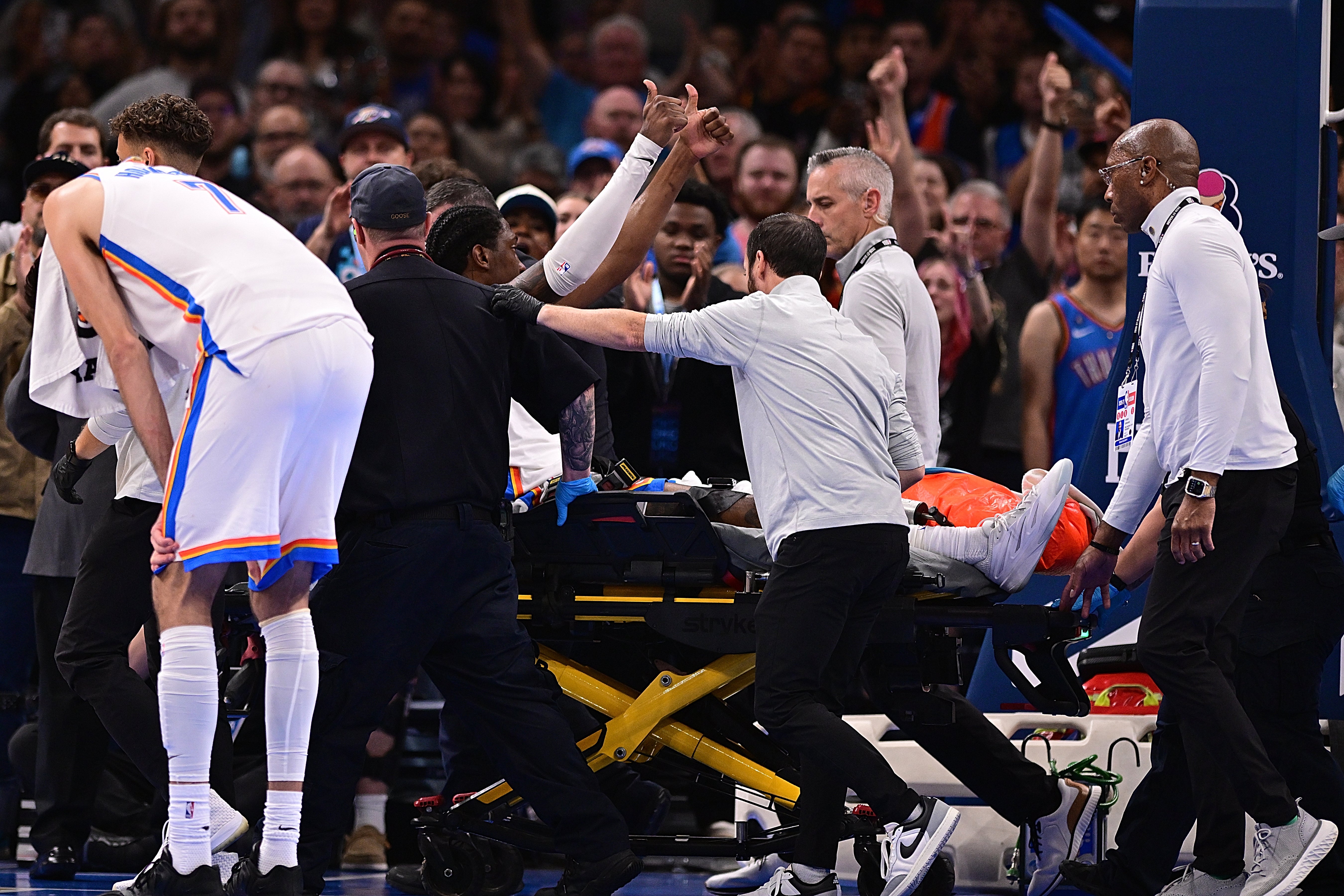Jalen Williams #8 of the Oklahoma City Thunder gives a thumbs up to the crowd while being carted off after an injury during the second half against the LA Clippers