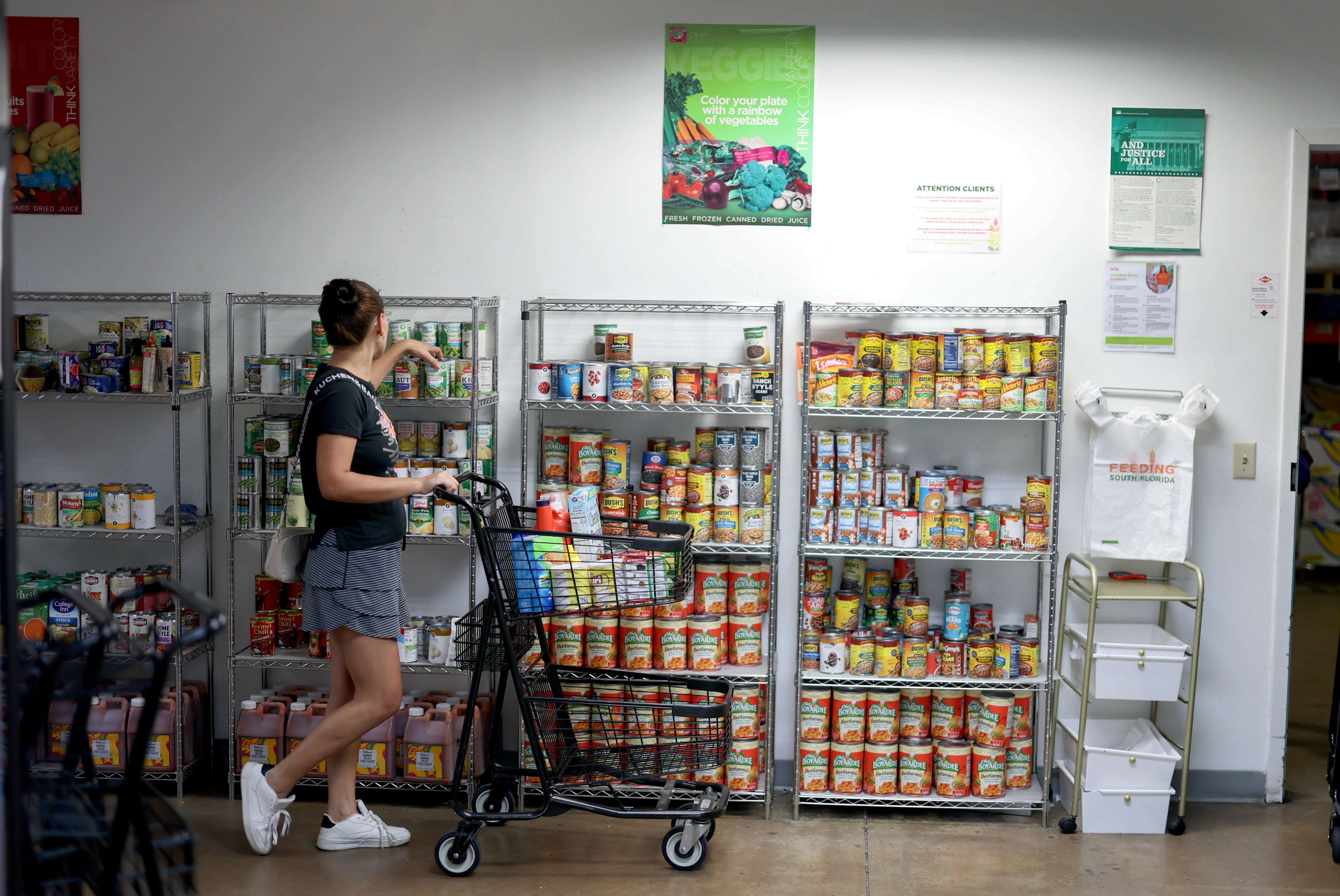 SNAP enrollment dropped from 41.6 million in July 2025 to 36 million in July 2026, according to new data. Pictured: a woman shops at a food pantry in Florida in October 2025