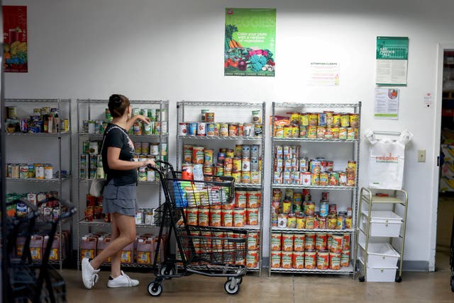 SNAP enrollment dropped from 41.6 million in July 2025 to 36 million in July 2026, according to new data. Pictured: a woman shops at a food pantry in Florida in October 2025