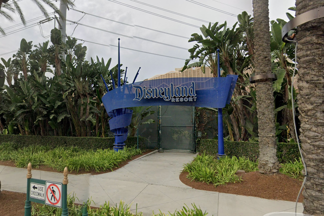 A body was discovered near the southern entrance of Disneyland in California. Authorities were spotted placing a partition barrier near one of the park's blue arch signs (pictured)