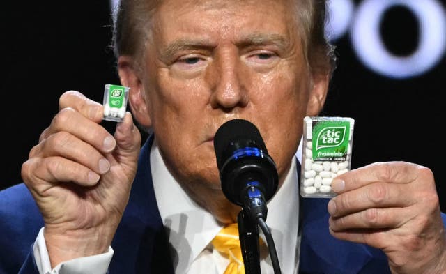 Trump holds a big and a small box of tic-tac to illustrate inflation outcome during a town hall event at Dream City Church in Phoenix, Arizona, on June 6, 2024