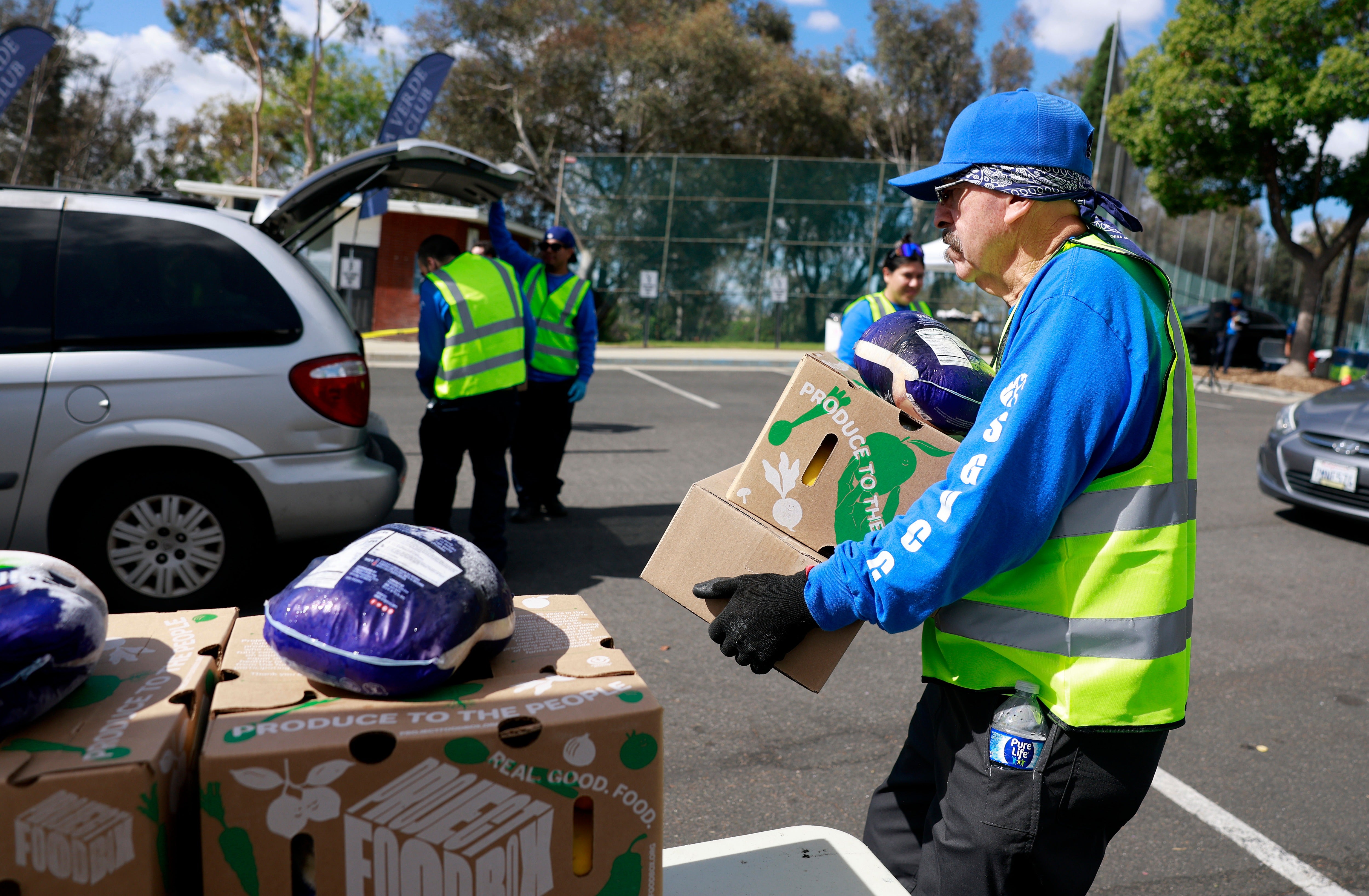 Volunteers load boxes of food into a car during a drive-thru food distribution at Montebello Golf Course on May 29, 2026 in Montebello, California