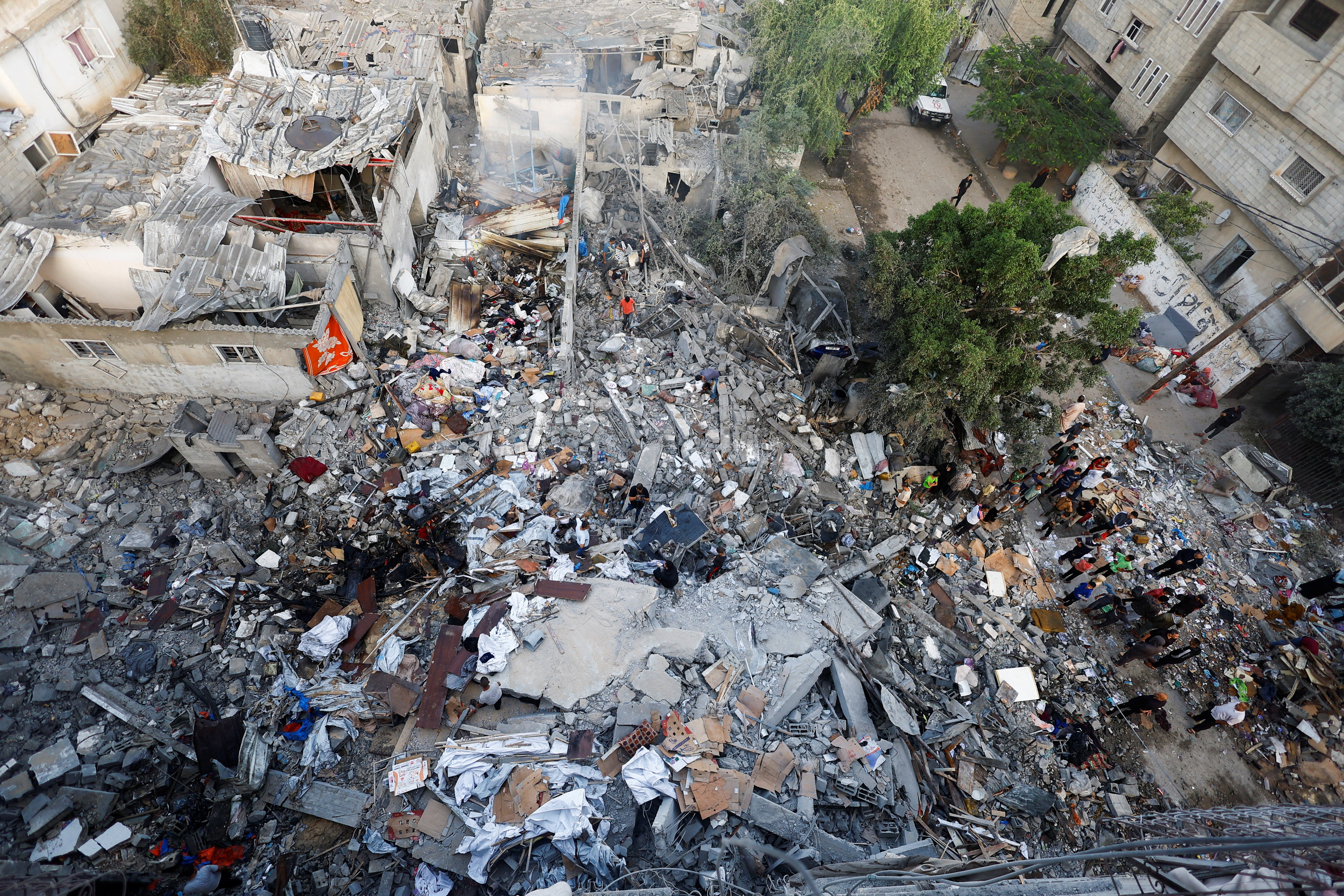 Palestinians inspect the site of a house targeted by an Israeli airstrike in Nuseirat in the central Gaza Strip, on October 23