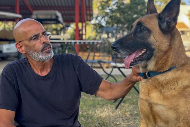 Gal Cohen sits with his dog, Koda