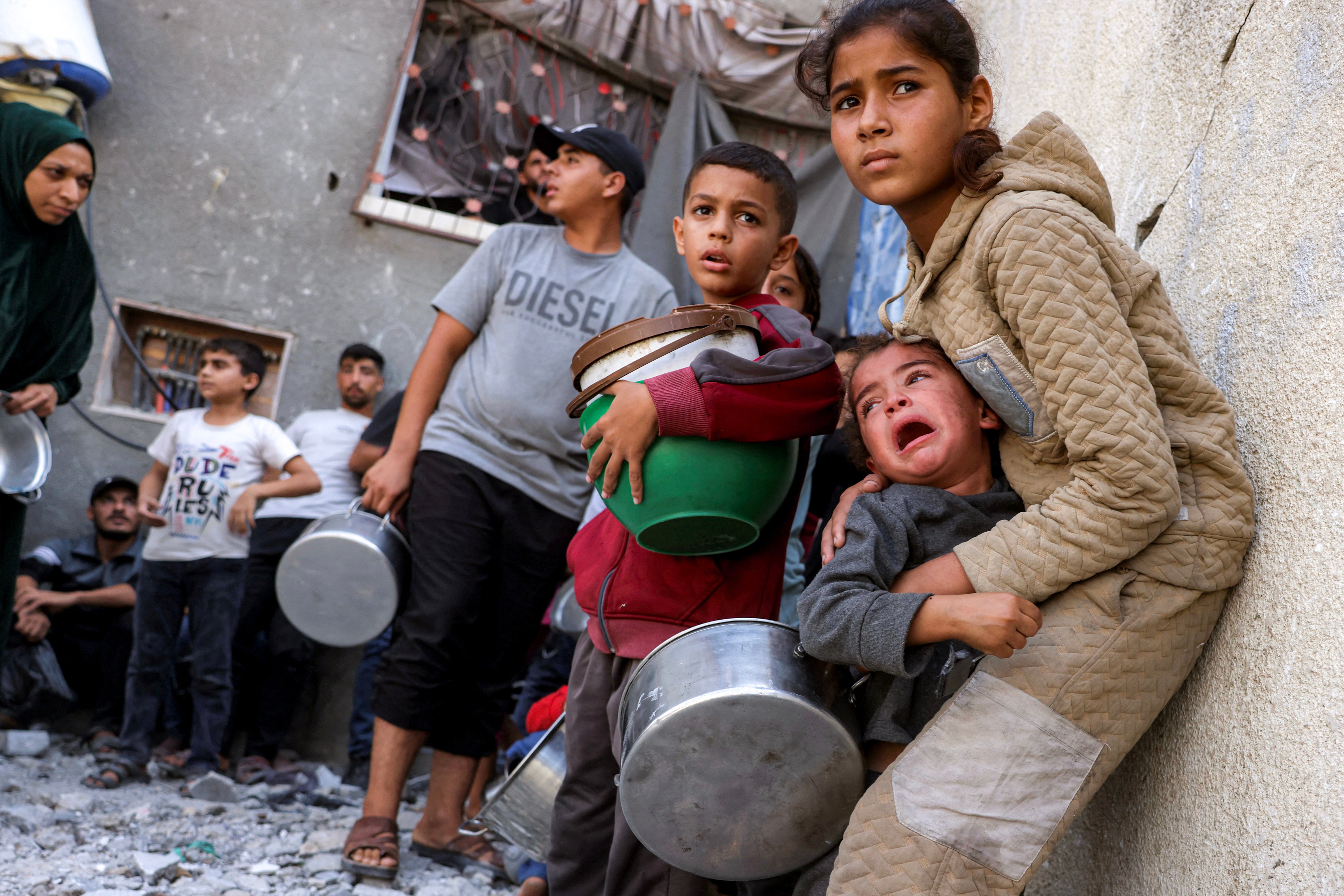 Palestinians take cover from a reported drone strike while they were queueing to receive meals from a charity kitchen in the Jabalia camp, on October 24