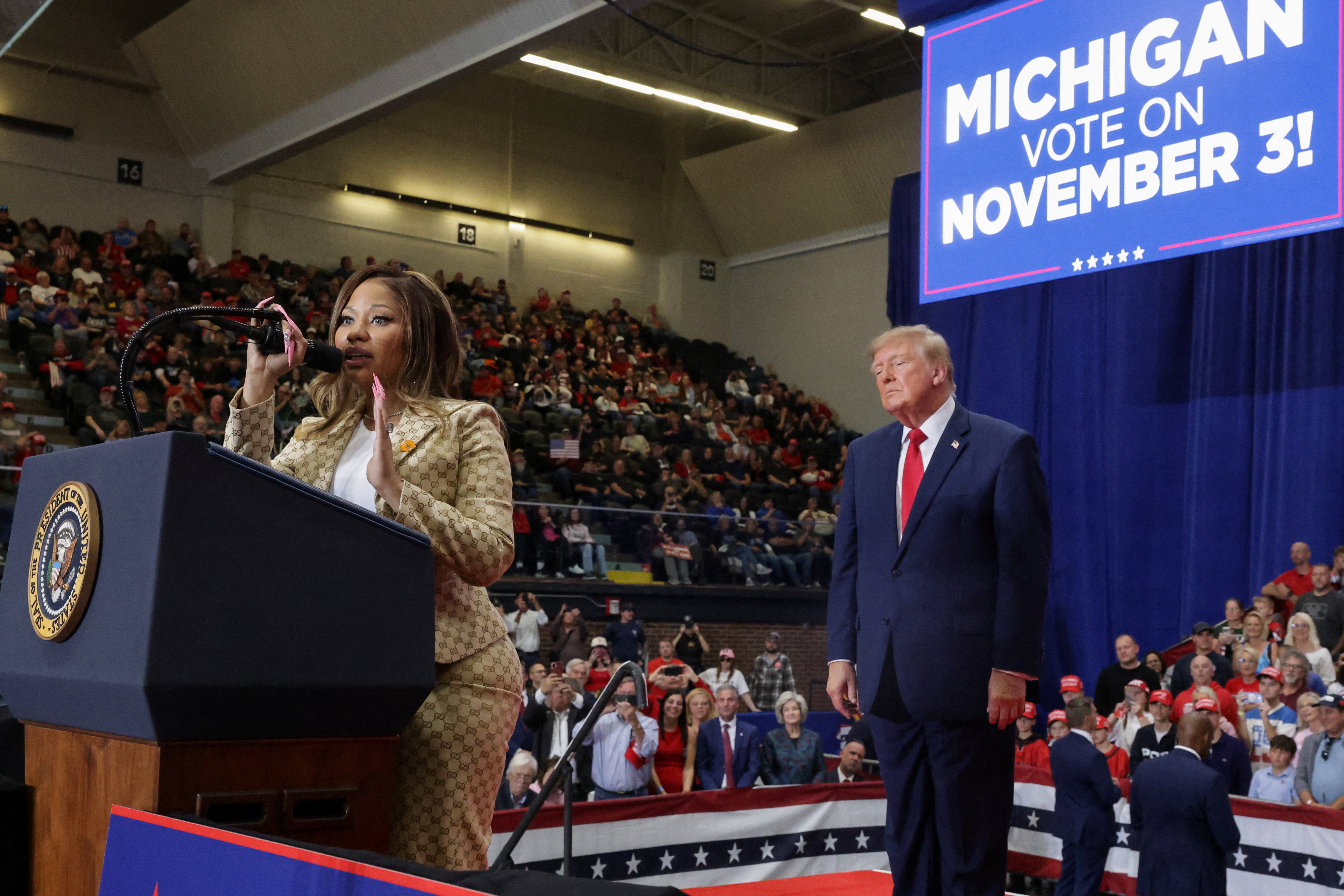 Trump appears to be taking it all in as Minaj speaks during the rally in support of Mike Rogers in Port Huron, Michigan, on Sunday