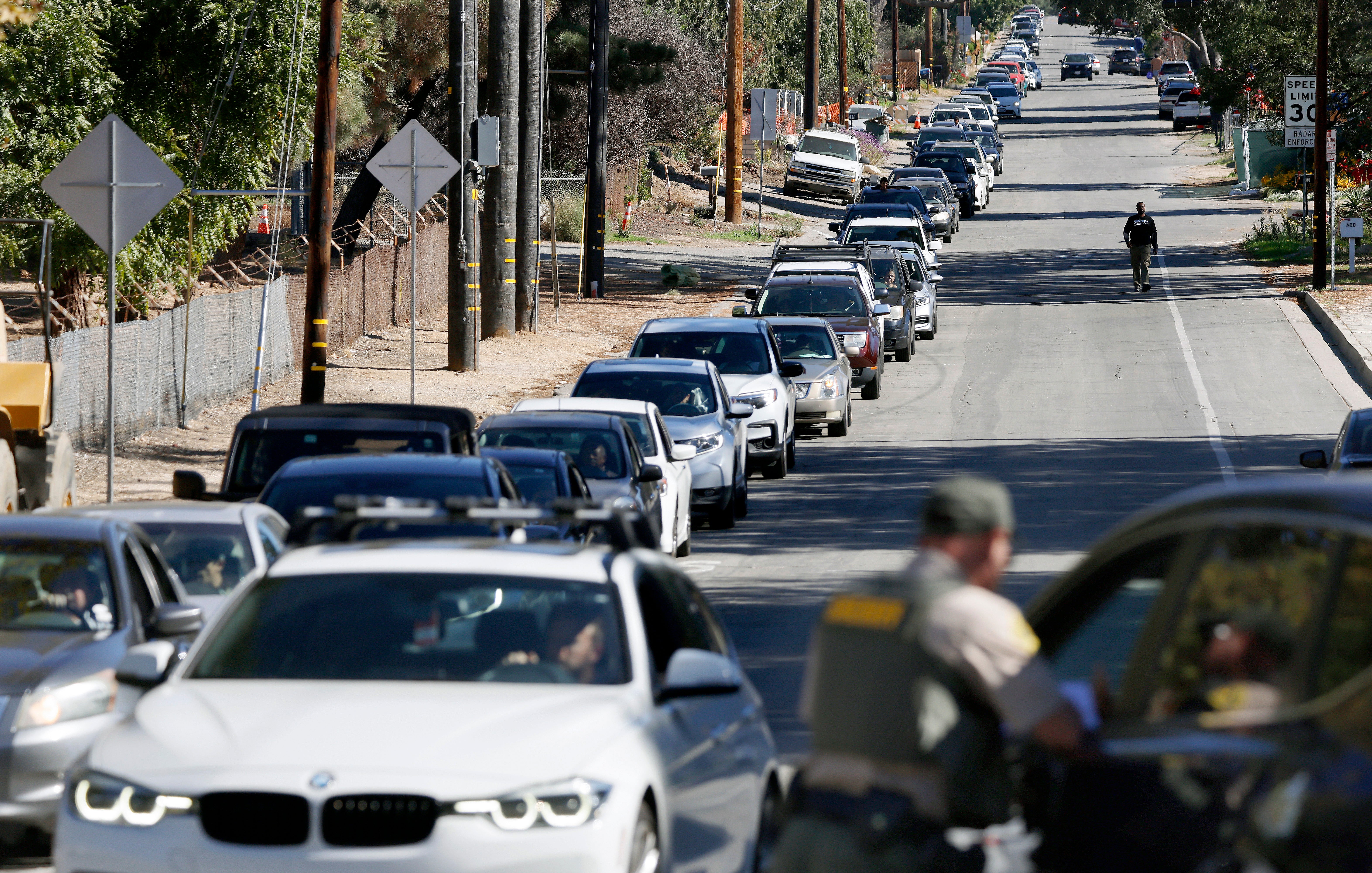 Motorists wait in line to receive free Thanksgiving food baskets in 2025 at an event held by the Brotherhood Crusade