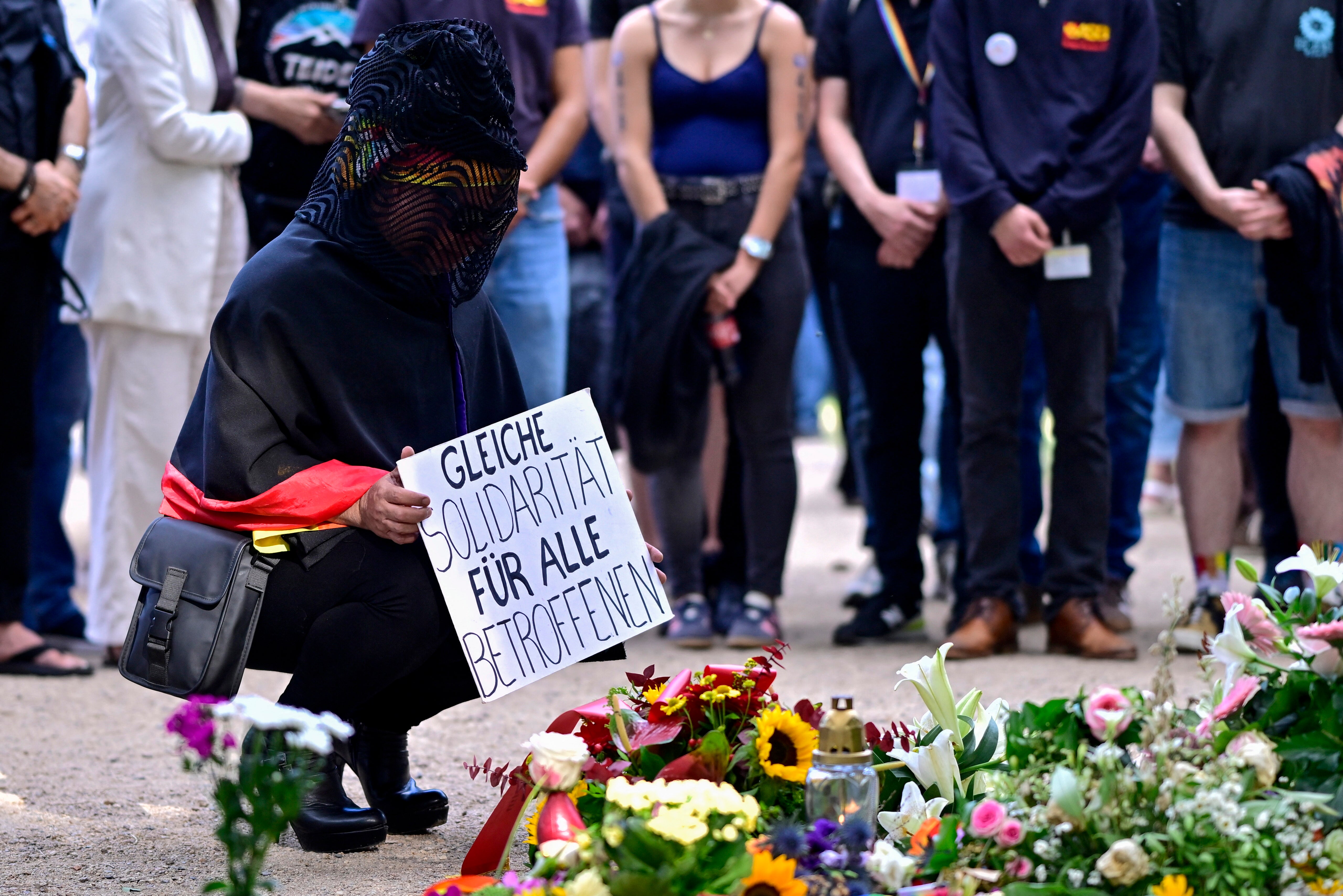 A mourner holds a placard which reads 