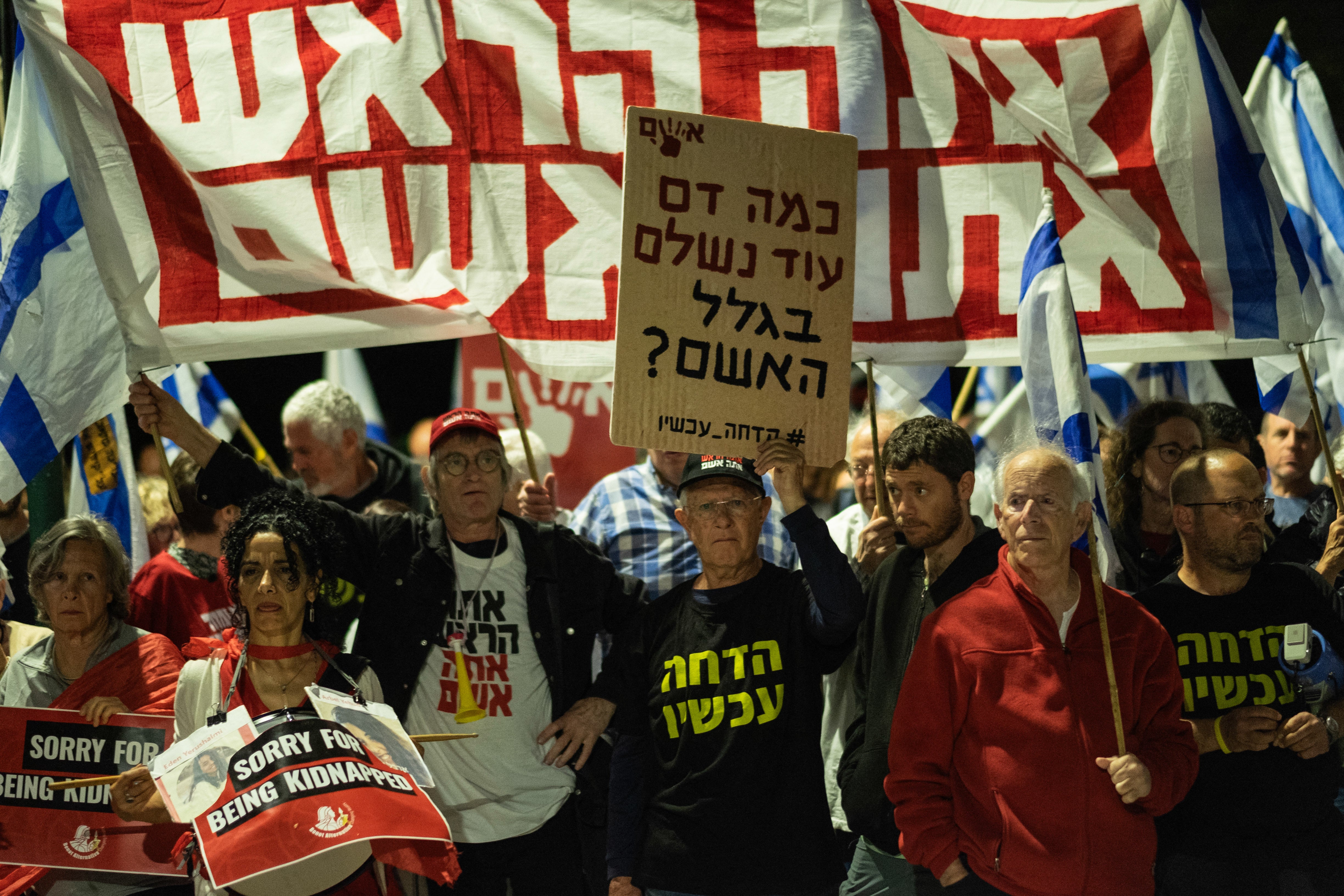 A group of protesters holds banners reading 