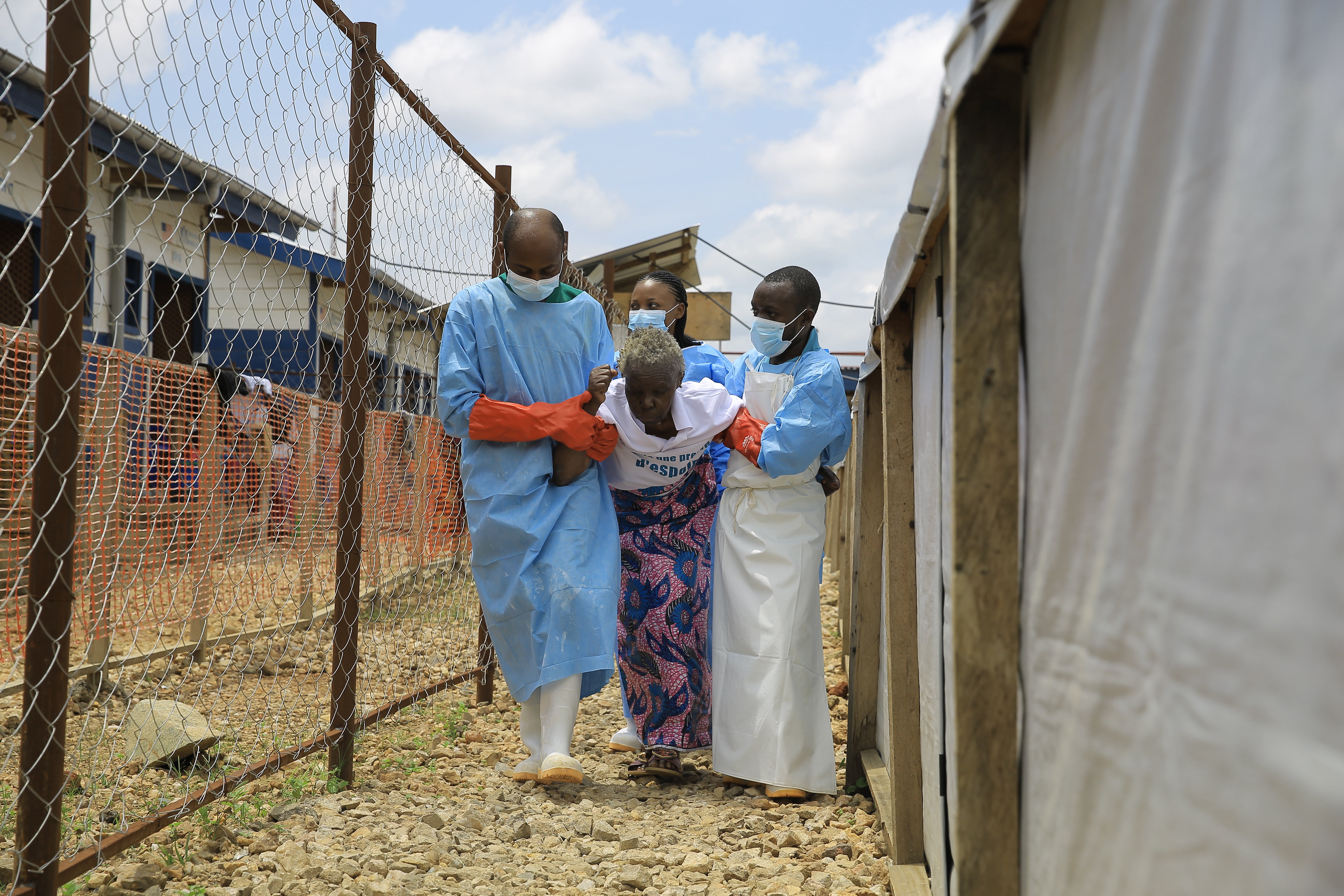 Healthcare workers help a patient who was cleared of Ebola virus inside a treatment center for Beni, North Kivu province, eastern Congo,