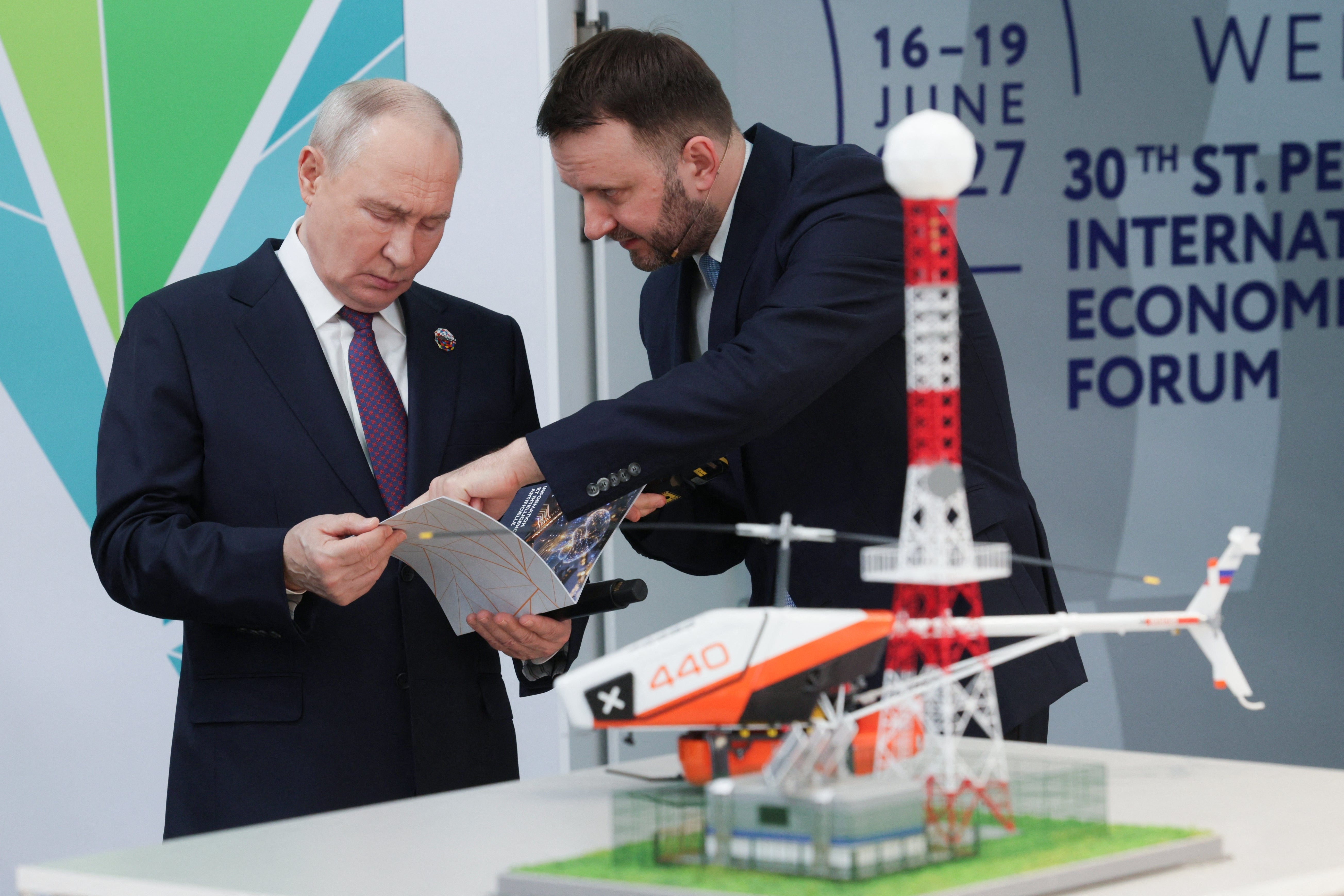 Russia's President Vladimir Putin listens to Deputy Chief of Staff of the Presidential Executive Office Maxim Oreshkin as he and African leaders tour an exhibition of advanced Russian solutions on the sidelines of the Russia-Africa summit