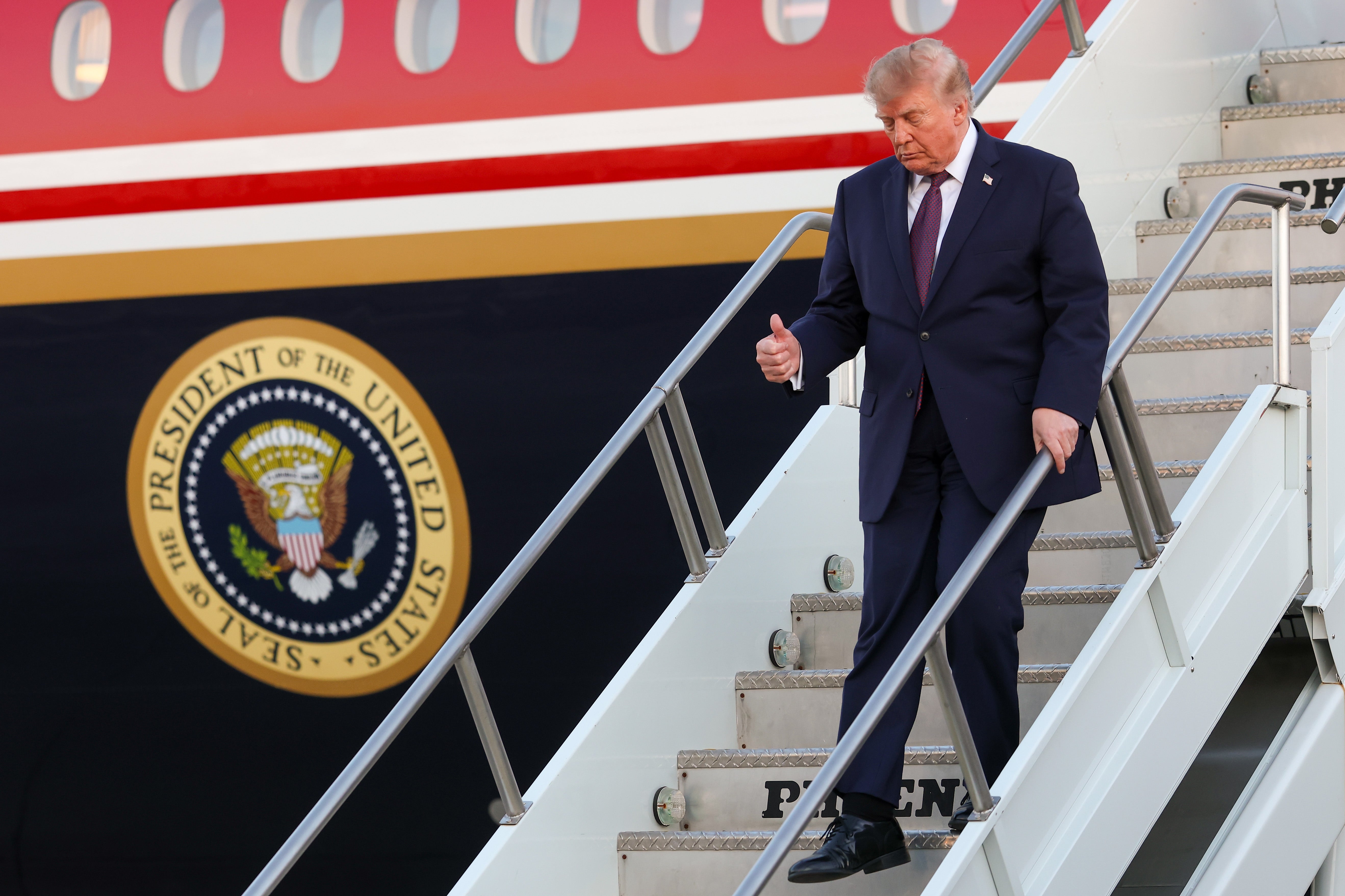 Donald Trump steps off the plane after landing on Air Force One at Rickenbacker International Airport