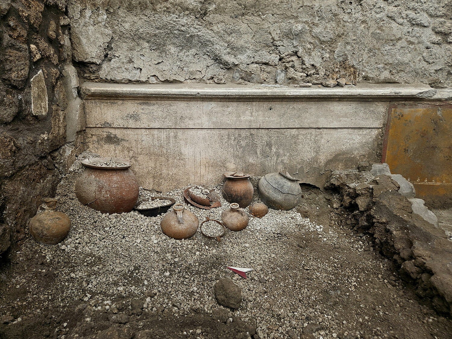 Pottery and other artefacts in the remains of a cupboard uncovered during archaeological excavations in Pompeii