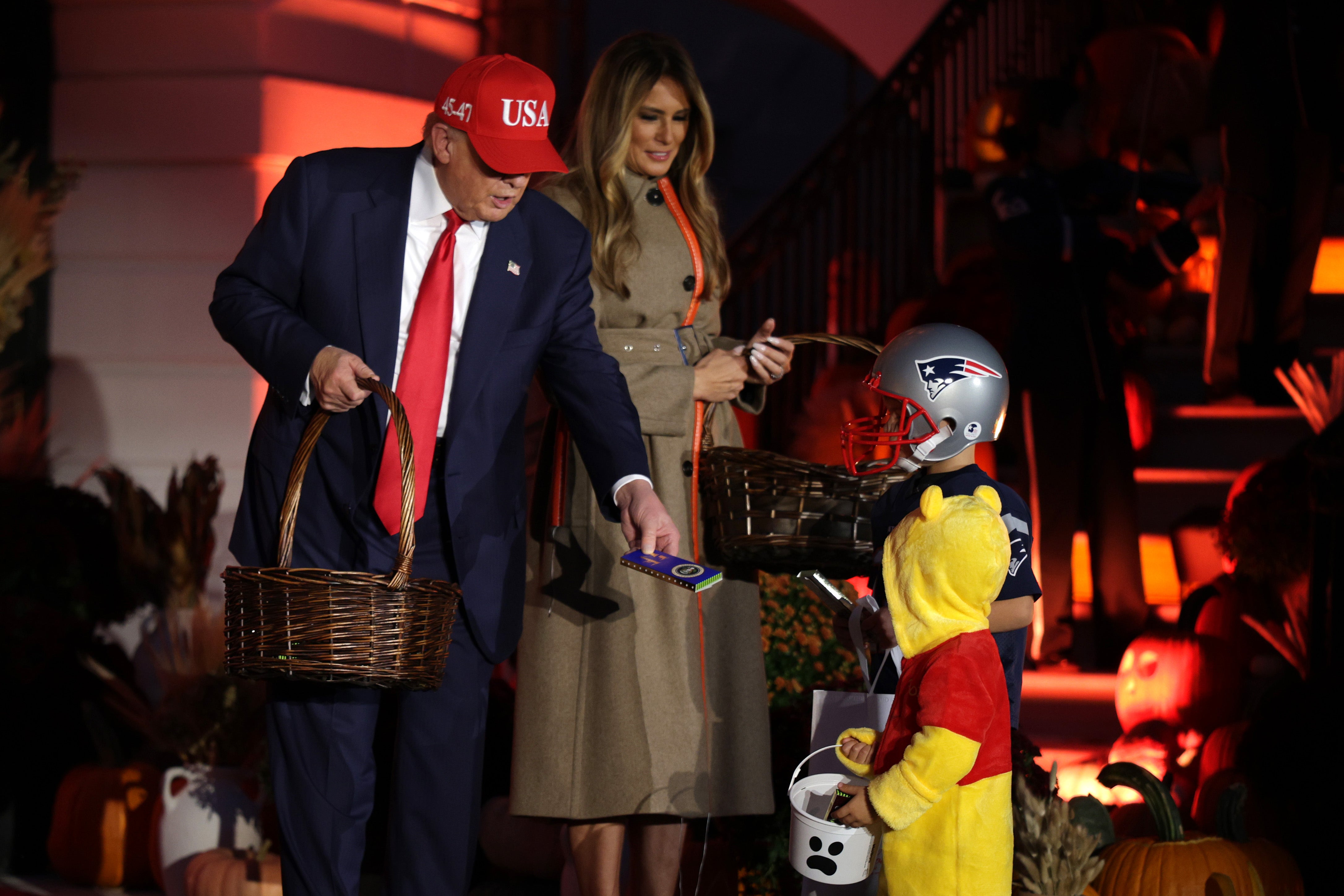 US President Donald Trump and first lady Melania Trump hand out candy to children during the annual Halloween event on the South Lawn of the White House on October 30, 2025 in Washington, DC