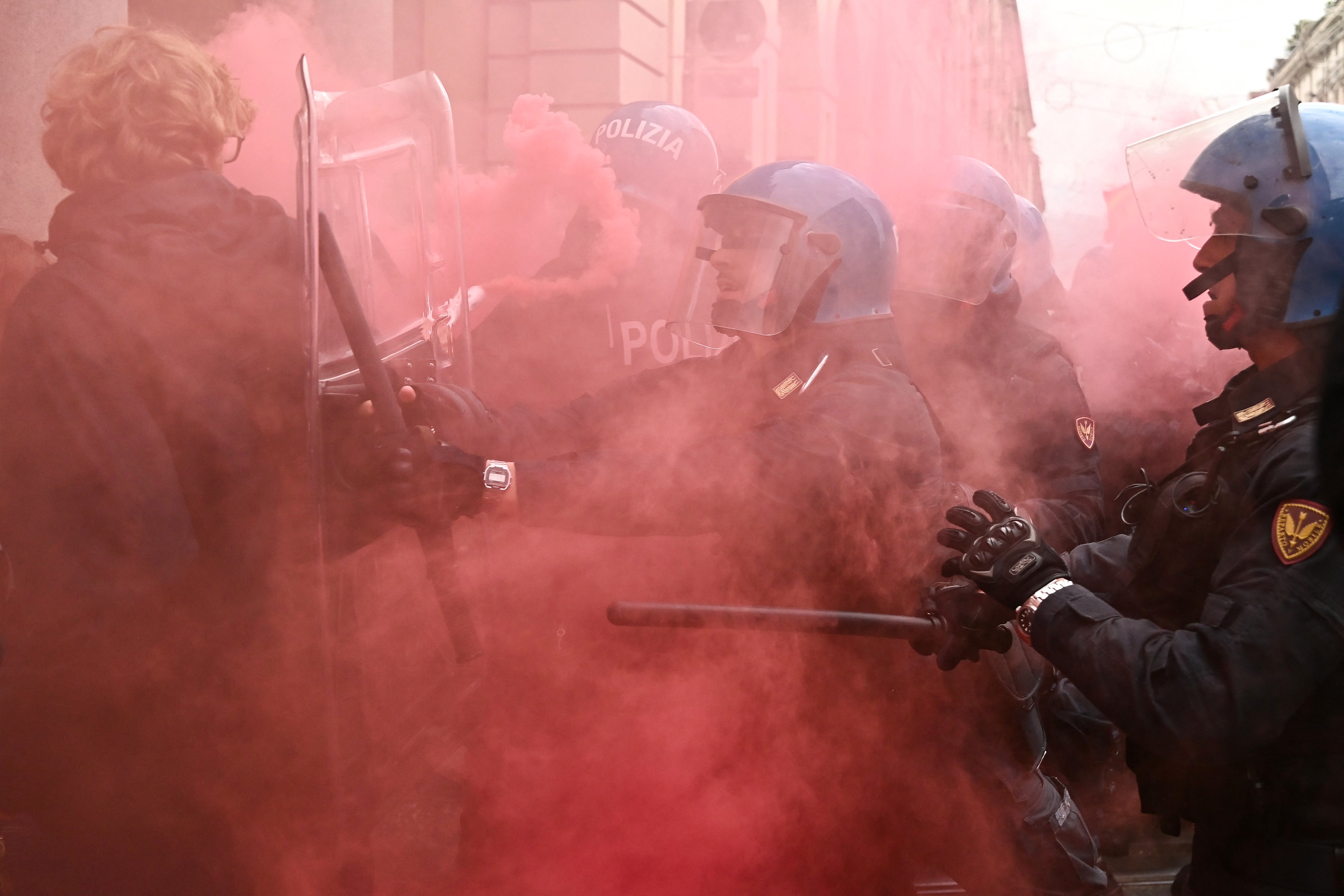 Protesters clash with police as a flare goes off in Turin on Friday