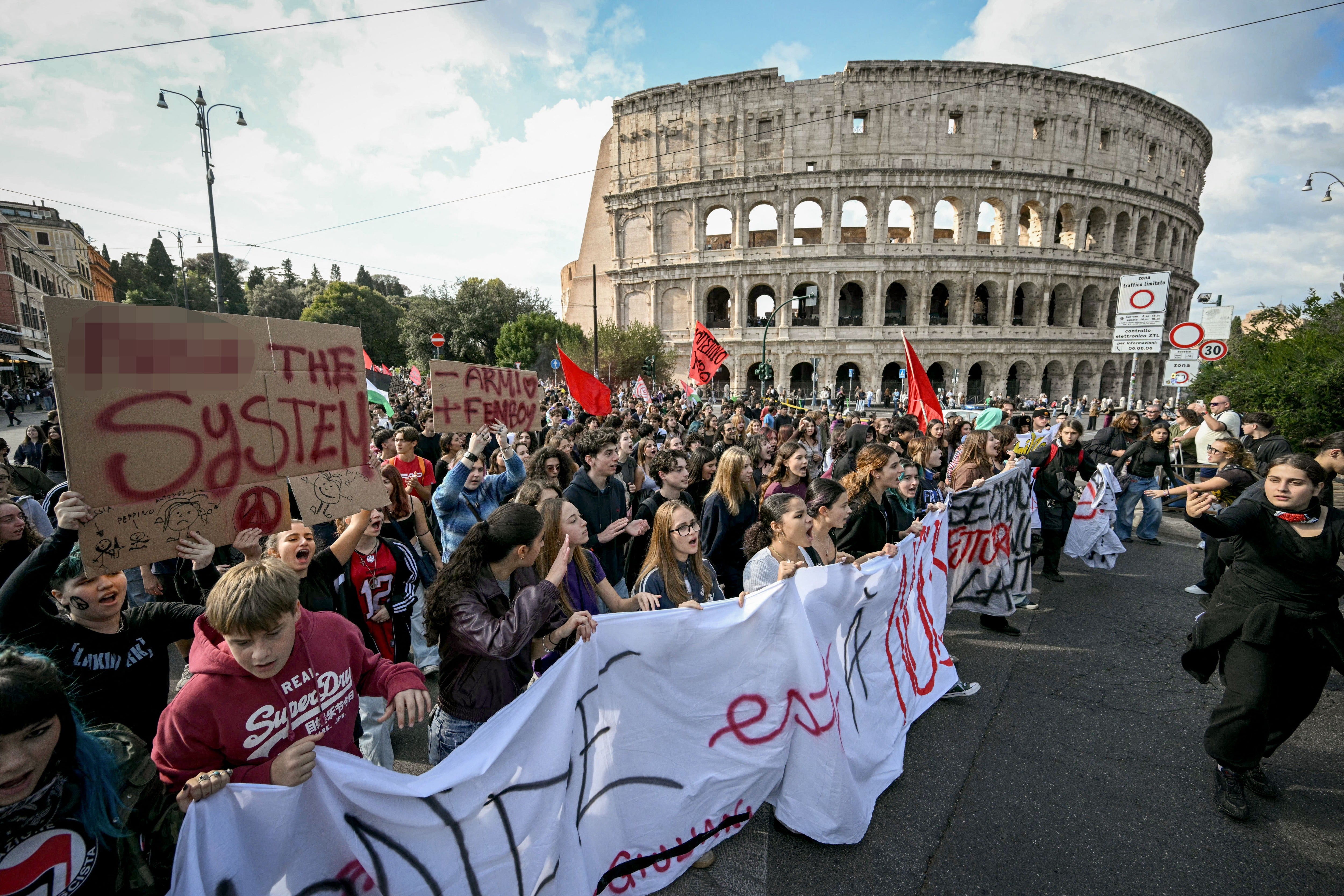 People pass by the Colosseum during a demonstration as part of a national day of strikes, on October 30