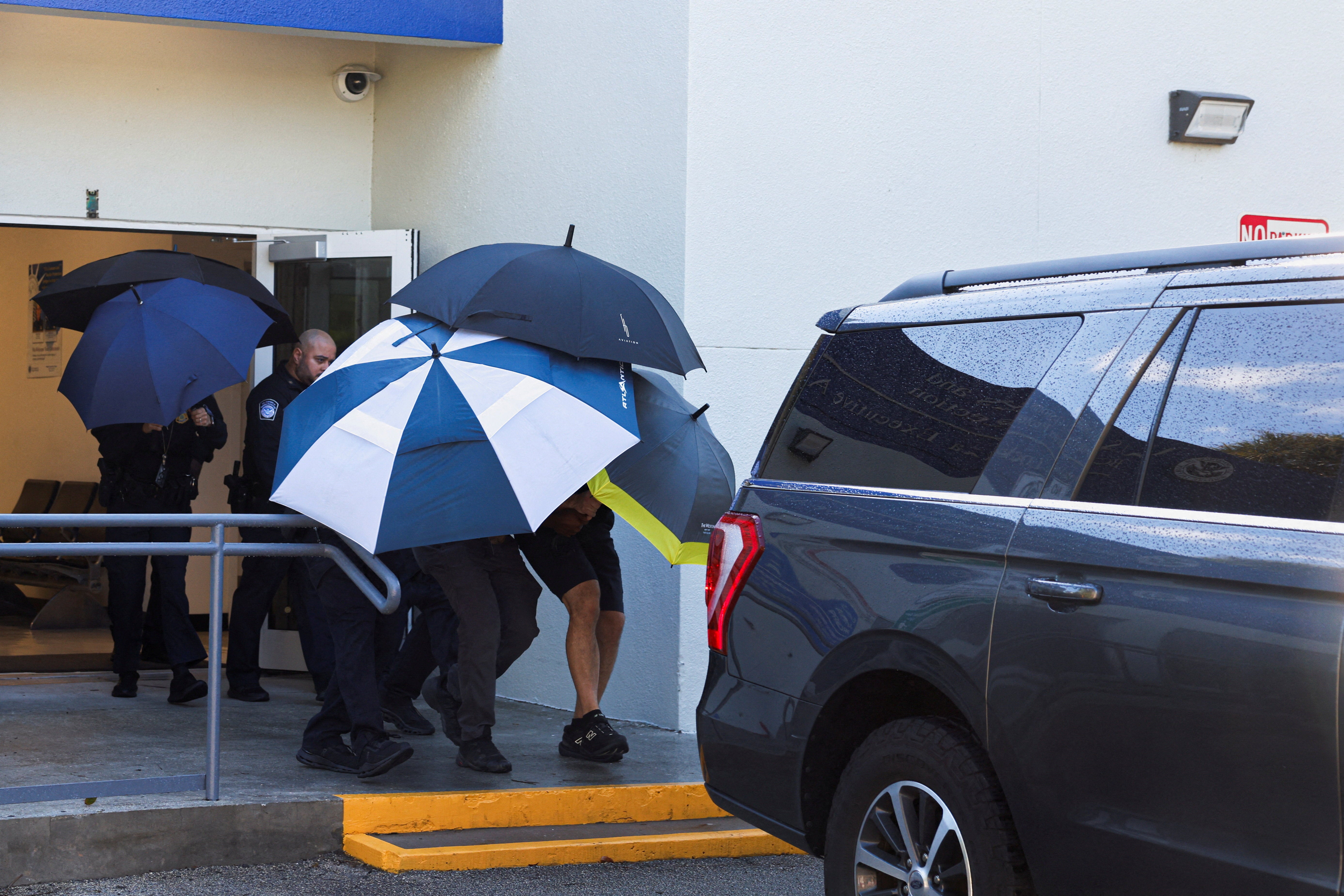 Flavio hid under umbrellas as he got into an SUV in Miami