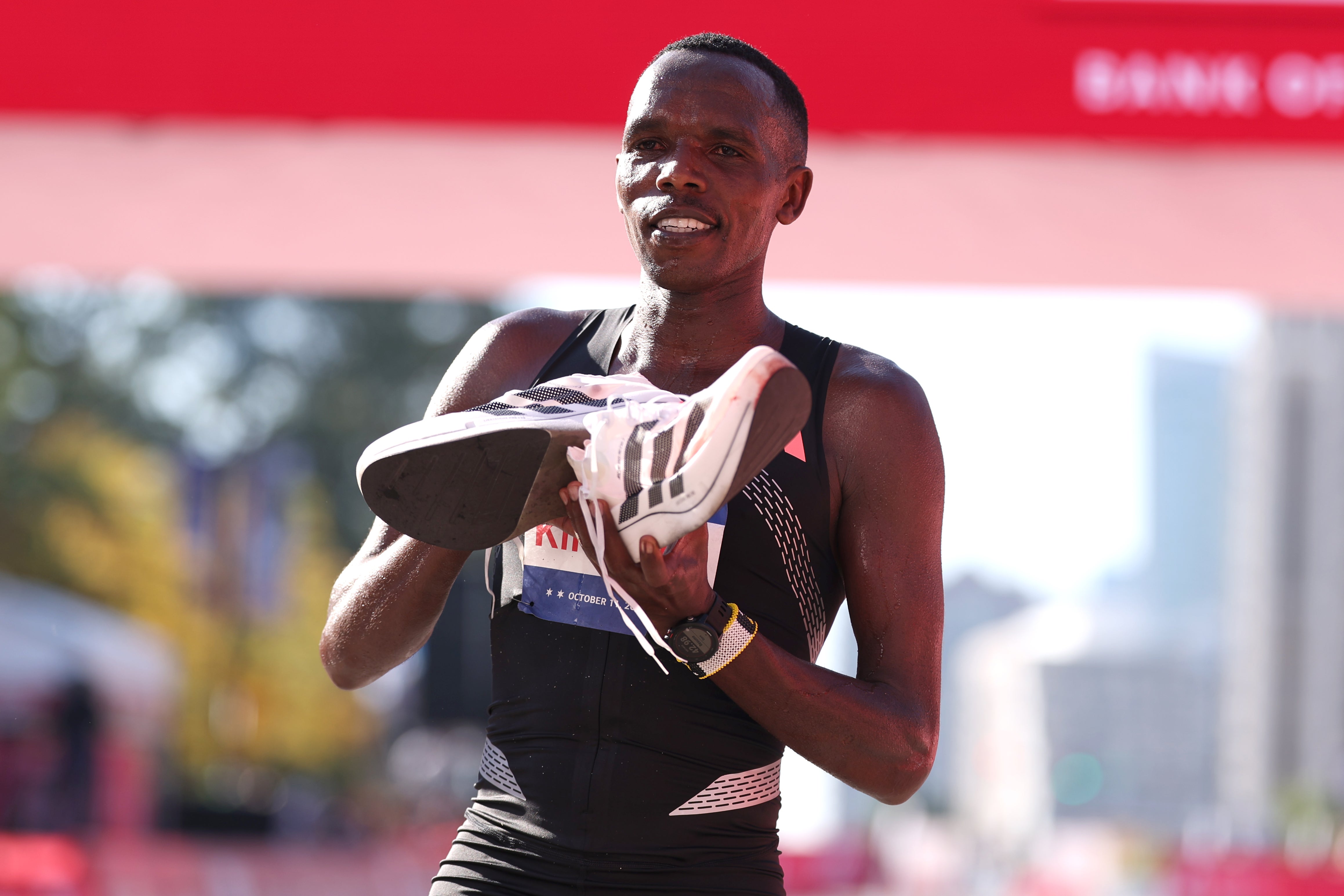 Amos Kipruto of Kenya celebrates winning the Chicago Marathon while showing off his Adidas shoes