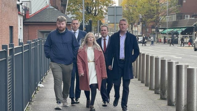 Sinn Féin councillor Catherine Nelson accompanied by North Belfast MP John Finucane (right) and solicitor Padraig O Muirigh (second left) arriving at Musgrave Police Station (Rebecca Black/PA) ( PA Wire )