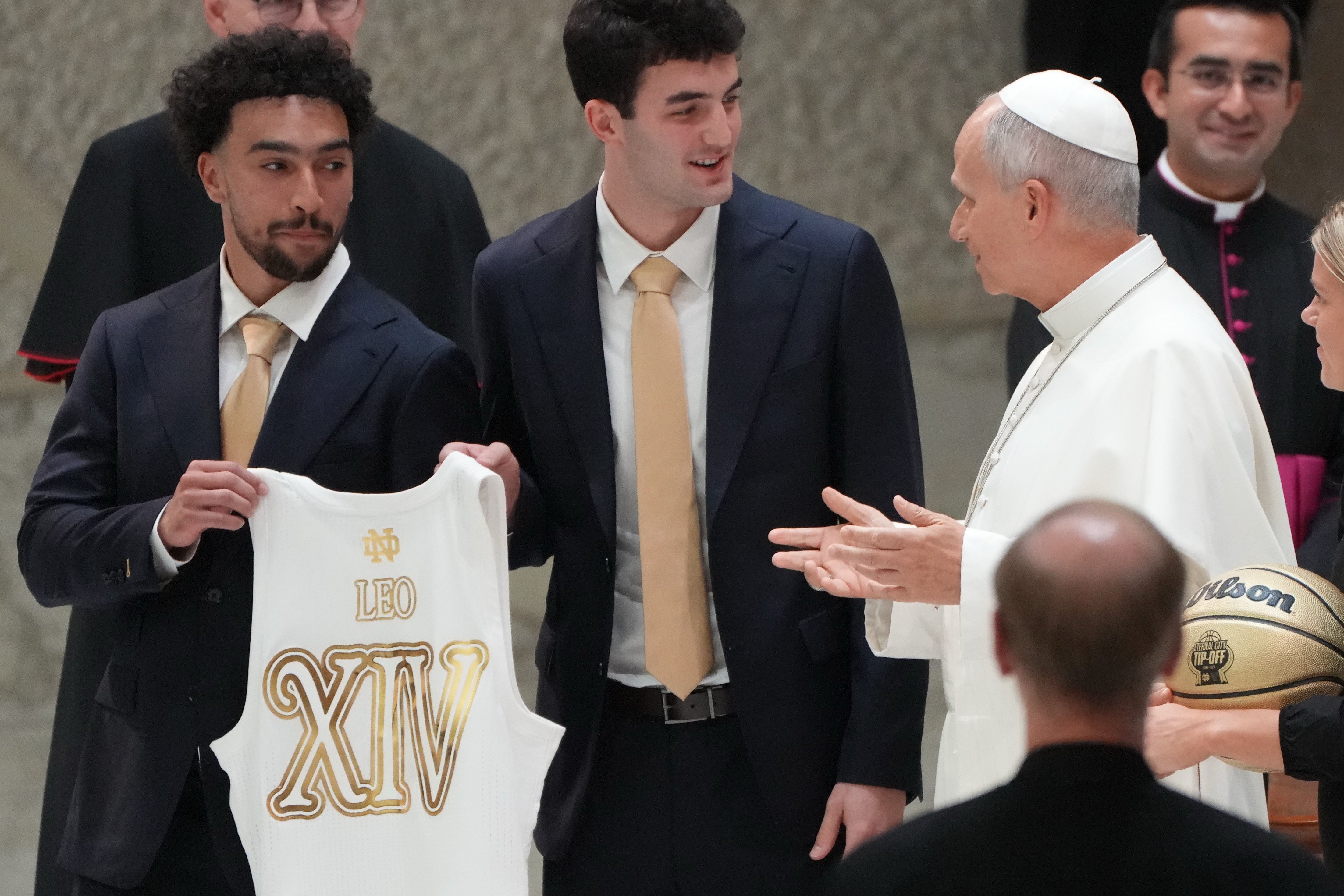 From left, Notre Dame's guards Braeden Smith and Logan Imes present Pope Leo XIV with a personalized Notre Dame's jersey and basketball