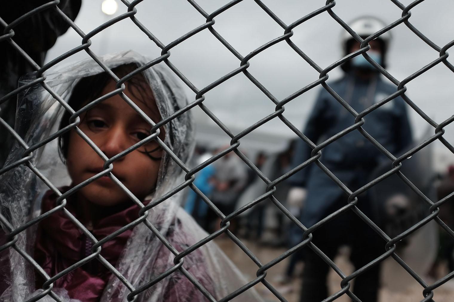 A child waits with her father at the migrant processing center at the increasingly overwhelmed Moria camp on the island of Lesbos (Picture: Getty)