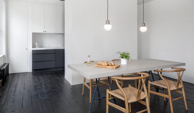 A sleek kitchen is hidden from the living room behind a deep central partition.