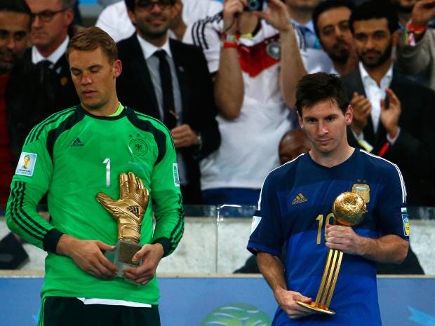 A devastated Messi holds the Golden ball alongside Germany's Manuel Neuer