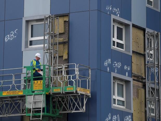 A worker removes cladding from a residential tower block in Cranford in west London,
