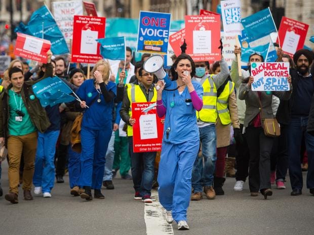 Junior doctors and their supporters stage a 'masked march' protest in London over pay and conditions