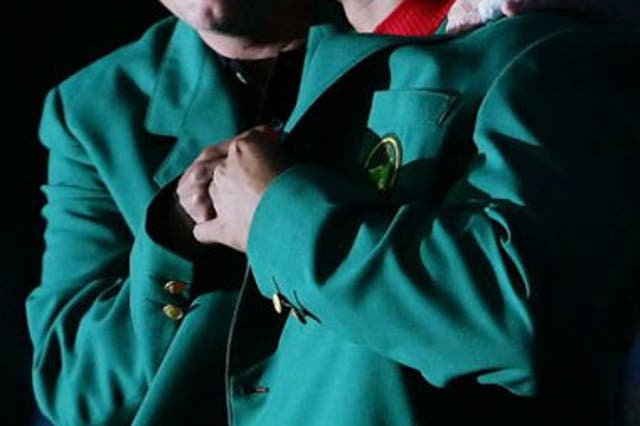 Phil Mickelson presents Woods with his fourth Green Jacket after victory at Augusta in 2005