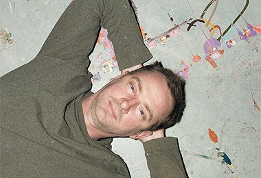 Gary Hume recliningon the floor of hiseast-London studio