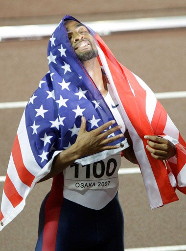 Tyson Gay wraps himself in the Stars and Stripes after winning the men's 200m final in Osaka