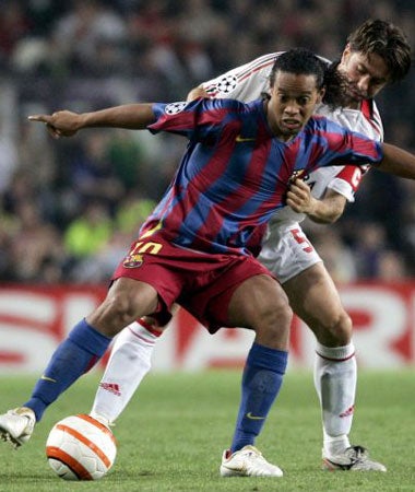 Ronaldinho battles for the ball with Milan defender Costacurta