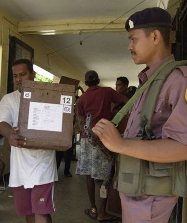 A Sri Lankan police officer stands guard as ballot boxes are collected in Colombo