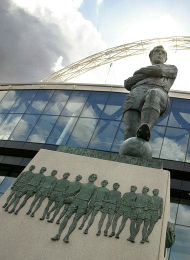 The new Wembley towers over the statue of England's World Cup-winning captain, Bobby Moore, and his team