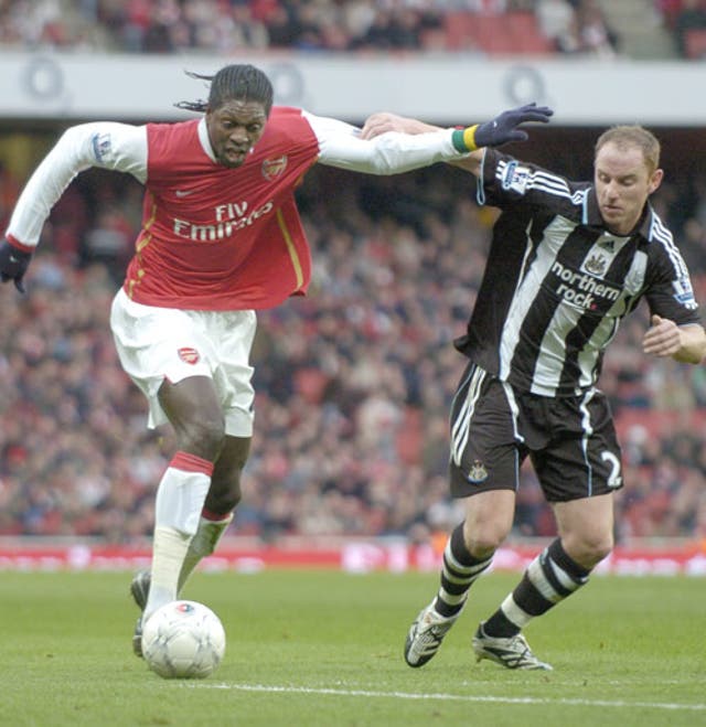 Emmanuel Adebayor (left), who scored twice, holds off Nicky Butt who scored a late own goal at the Emirates