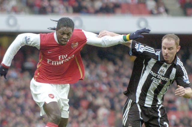 Emmanuel Adebayor (left), who scored twice, holds off Nicky Butt who scored a late own goal at the Emirates
