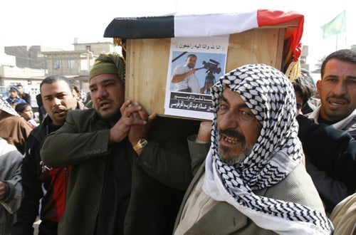 Relatives carry the coffin of Alaa Abdul-Karim al-Fartoosi, a journalist killed by a roadside bomb in Baghdad