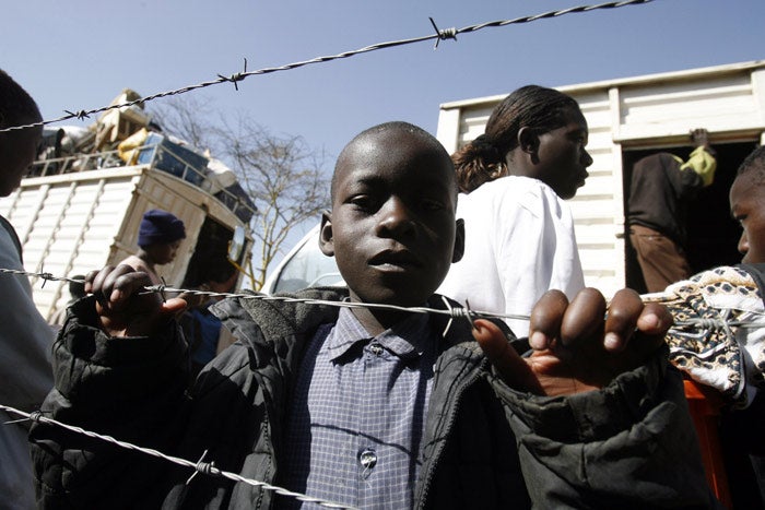 A boy left homeless by the wave of post-election violence takes refuge in a police station compound