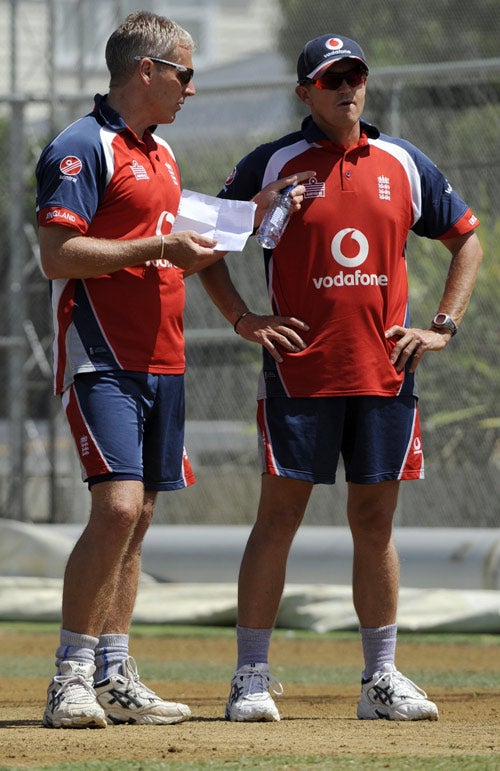 Moores (left) discusses tactics with his assistant coach Andy Flower