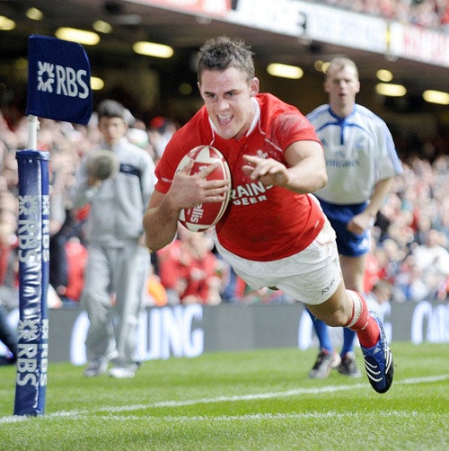 Wales full-back Lee Byrne goes over for the first of his two tries during the thrashing of Italy at the Millennium Stadium