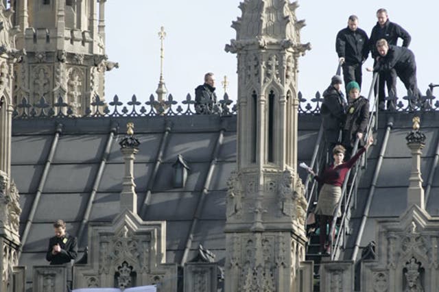 Protesters calling for a halt to the expansion of Heathrow hold paper planes on Parliament's roof