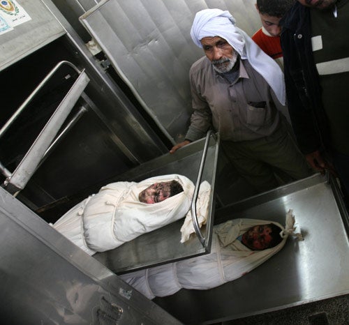 The bodies of two boys killed by Israeli air strikes, according to Palestinian officials, lie in a morgue in Gaza