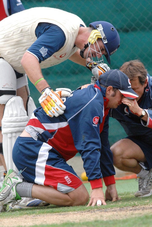 Phil Mustard is treated after having his nose broken by a ricocheting shot from Kevin Pietersen (left)