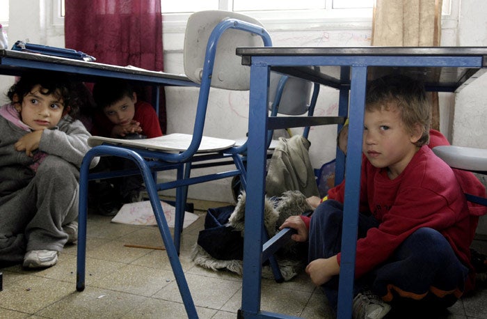 Israeli school children take shelter under desks in their classroom during a rocket simulation drill in Ashkelon