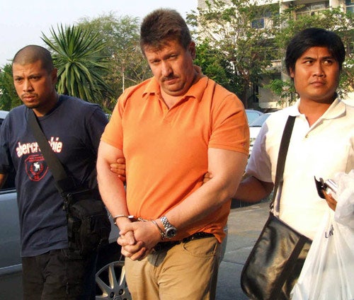 Thai security officers escort Viktor Bout from the five-star hotel where he was arrested yesterday