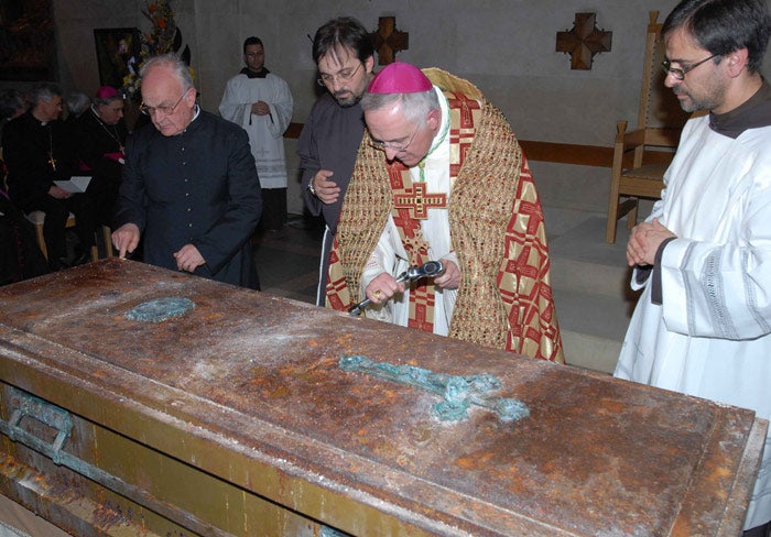 Archbishop D'Ambrosio prises the lid from Padre Pio's coffin